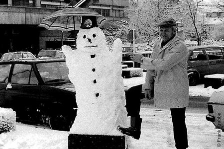 Hausmeister neben Schneemann